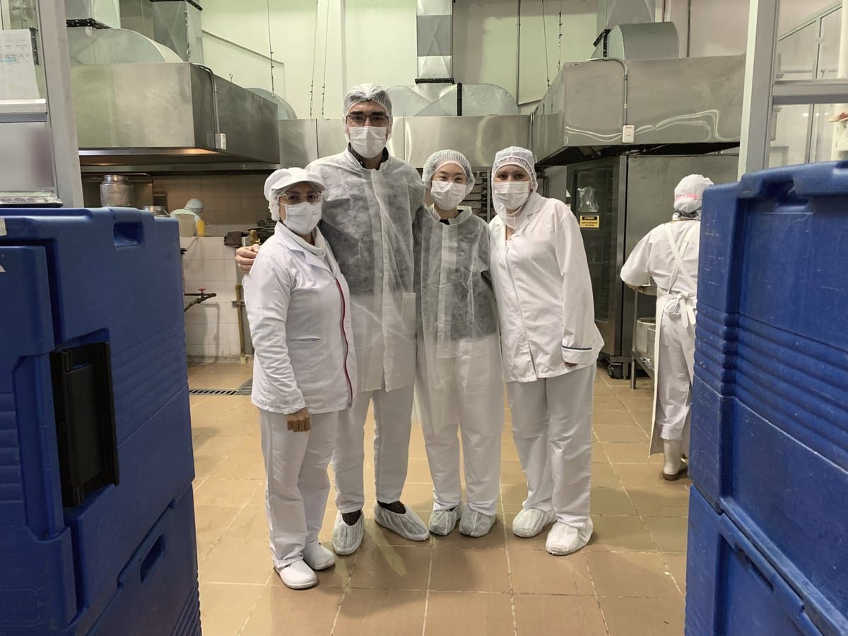 David Herrera in hygiene clothing with colleagues in a food production plant